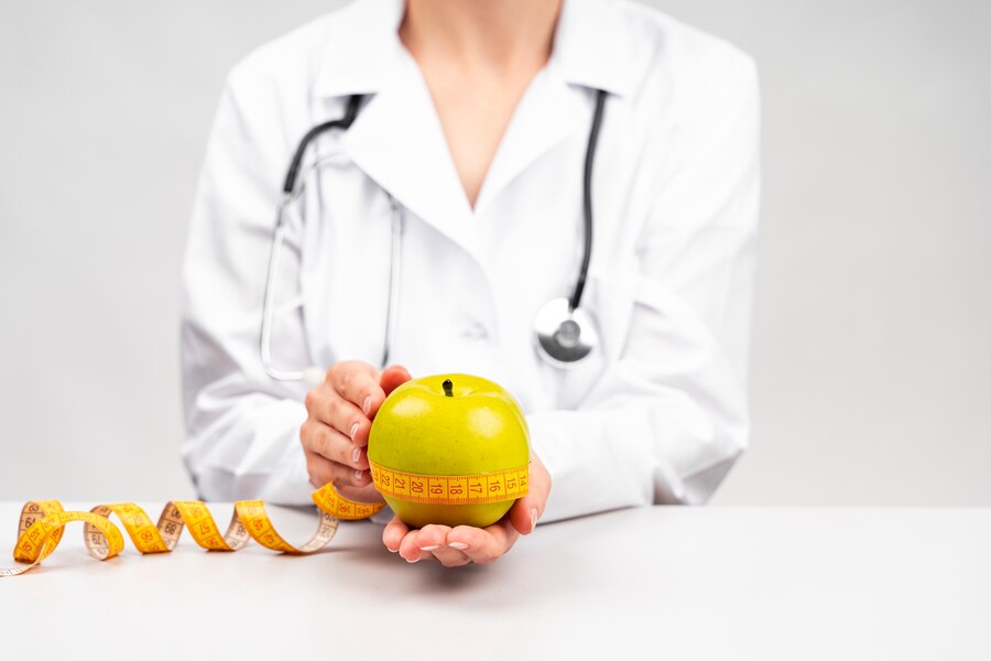 medical expert in weight management - nutritionist holding an apple
